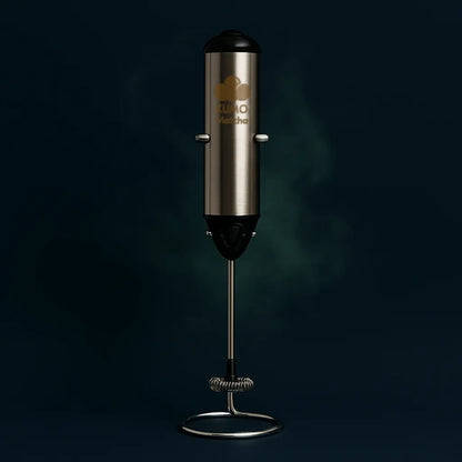 Stainless steel milk frother with black top on a dark background